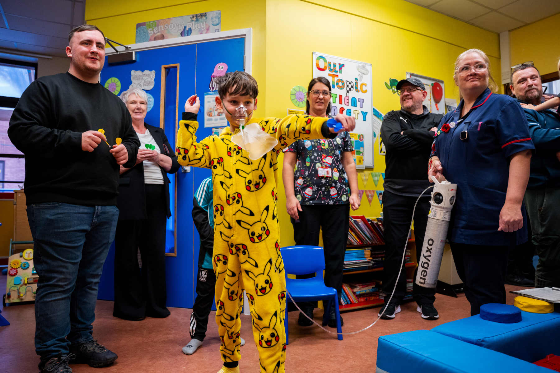 Patient Archie, aged 9, playing darts with Luke Littler